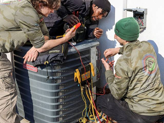 Green Comfort technicians running gauge diagnostics during a seasonal tune-up