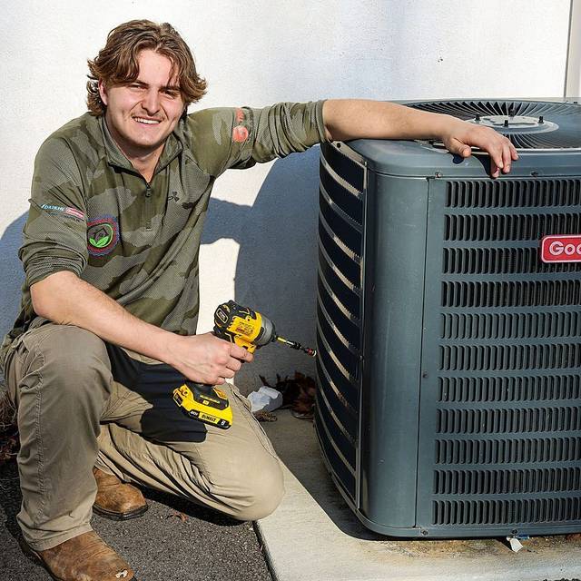 Green Comfort Systems technician finishing an AC condenser install